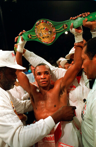 FILE &mdash; Sugar Ray Leonard holds up the middleweight championship belt after defeating Marvin Hagler in a split decision to win the title in Las Vegas, Nev., April 6, 1987. A World Boxing Council championship belt belonging to former South African President Nelson Mandela has been stolen from a museum in Soweto. The belt was given to Mandela by American boxing legend Leonard during one of his visits to South Africa. (AP Photo/Lennox McLendon/File)