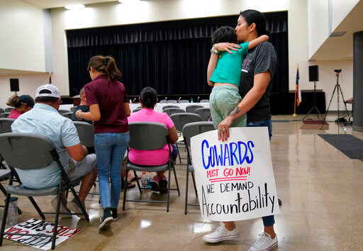 FILE - Rachel Martinez carries her son and a protest sign as she attends a city council meeting, on July 12, 2022, in Uvalde, Texas. A Texas lawmaker says surveillance video from the school hallway at Robb Elementary School where police waited as a gunman opened fire in a fourth-grade classroom will be shown this weekend to residents of Uvalde. (AP Photo/Eric Gay, File)