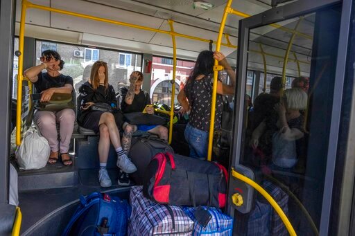 People wait on an evacuation bus, in Kramatorsk, eastern Ukraine, Tuesday, July 19, 2022. Donetsk Pavlo Kyrylenko said four Russian strikes had been carried out on the city of Kramatorsk, and he urged civilians to evacuate. (AP Photo/Nariman El-Mofty)