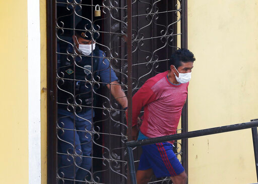 FILE - Oseney da Costa de Oliveira, is led out a courthouse by military and civil police officers in Atalia do Norte, Amazonas state, Brazil, June 15, 2022, after his arrest and that of his brother Amarildo, as a main suspect in the disappearance of British journalist Dom Phillips and Indigenous expert Bruno Pereira. Prosecutors presented their charges on July 21, 2022, outlining that two of the men &mdash; Amarildo da Costa Oliveira and Jefferson da Silva Lima &mdash; have confessed to the crime, while witness testimony indicates Oseney also participated, according to the statement. (AP Photo/Edmar Barros, File)