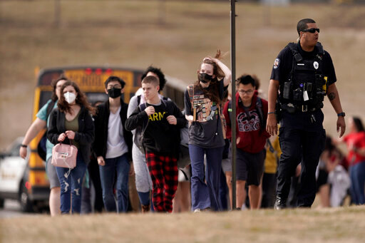 FILE - Students from Olathe East High School are lead to a staging area to reunite with their parents after a shooting at the school in Olathe, Kan., on March 4, 2022. A school resource officer who shot and wounded a Kansas high school student during a confrontation in March believed his life was in danger and will not face charges, a prosecutor announced Friday, July 22, 2022. (AP Photo/Charlie Riedel, File)