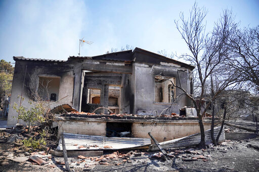 A view of a burnt house following a forest fire near the beach resort of Vatera, on the eastern Aegean island of Lesbos, on Sunday, July 24, 2022. A fire that broke Saturday morning on the Greek island of Lesbos prompted authorities to call for the evacuation of the Vatera resort on the south side of the island. (AP Photo/Panagiotis Balaskas)