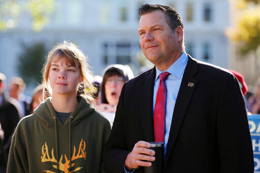 FILE - In this Oct. 30, 2021, file photo, former Kansas Secretary of State Kris Kobach, right, follows a rally against COVID-19 vaccine mandates with his oldest daughter, 15-year-old Reagan, left, outside the Kansas Statehouse in Topeka, Kan. Kobach is running for Kansas attorney general. (AP Photo/John Hanna, File)