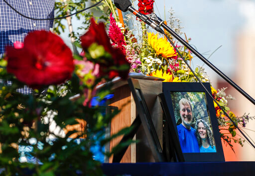 A photo of Tyler and Sarah Schmidt sits on the podium during the Celebration of Life event for Tyler, Sarah, and Lula Schmidt held at Overman Park on Tuesday, Aug. 2 2022 in Cedar Falls, Iowa. The Schmidt's were shot and killed at Maquoketa Caves State Park on July 22. (Chris Zoeller/The Courier via AP)