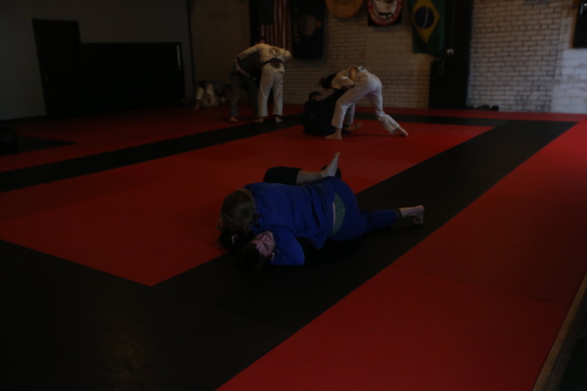Elicia Hoy (in Blue) attempts to pin her opponent Ciaren Walker, as Seth Weidert ( in Grey) works from the ground on Wednesday at Arise Brazilian Jiu-Jitsu Academy.