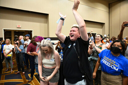 Allie Utley, left, and Jae Moyer, center, of Overland Park, react during a primary watch party Tuesday, Aug. 2, 2022, at the Overland Park (Kan.) Convention Center. Kansas voters on Tuesday protected the right to get an abortion in their state, rejecting a measure that would have allowed their Republican-controlled Legislature to tighten abortion restrictions or ban it outright. (Tammy Ljungblad/The Kansas City Star via AP)