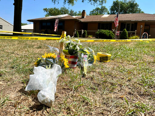 A small memorial sits outside the home of Gene Twiford, 86, Janet Twiford, 85, and Dana Twiford, 55, Friday, Aug. 5, 2022, in Laurel, Neb. The three were among four people found dead Thursday in two burning homes in this small community in northeastern Nebraska, authorities said. Police investigating the killings have arrested a neighbor of the victims, the Nebraska State Patrol said Friday. (AP Photo/Margery A. Beck)