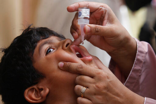 FILE - A health worker gives a polio vaccine to a child in Karachi, Pakistan, May 23, 2022. British health authorities on Wednesday, Aug. 10 say they will offer a polio booster dose to children aged 1 to 9 in London, after finding evidence the virus has been spreading in multiple regions of the capital, despite not confirming any cases of the paralytic disease in people. (AP Photo/Fareed Khan, file)