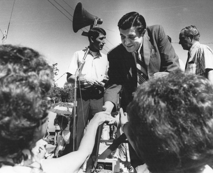 Gov. Robert Docking shakes hands with some of the hundreds of people who attended the annual V-J homecoming parade at Arma Saturday, Aug. 12, 1972. Immediately following the parade, Gov. Docking left by plane for Leavenworth for another appearance. Homecoming officials may be seen in the background on the speaker&rsquo;s platform.