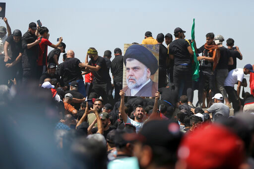 FILE -  A protester holds a poster depicting Shiite cleric Muqtada al-Sadr on a bridge leading towards the Green Zone area in Baghdad, Iraq, Saturday, July 30, 2022 &mdash; days after hundreds breached Baghdad's parliament Wednesday chanting anti-Iran curses in a demonstration against a nominee for prime minister by Iran-backed parties. Iraq&rsquo;s political crisis shows no signs of abating weeks after followers of an influential cleric stormed parliament. That&rsquo;s despite rising public anger over a debilitating gridlock that has further weakened the country&rsquo;s caretaker government and its ability to provide basic services. (AP Photo/Anmar Khalil, File)