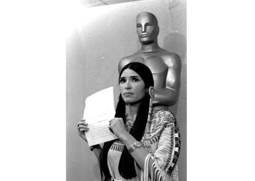 FILE - Sacheen Littlefeather appears at the Academy Awards ceremony to announce that Marlon Brando was declining his Oscar as best actor for his role in &quot;The Godfather,&quot; on March 27, 1973. The move was meant to protest Hollywood's treatment of American Indians. Nearly 50 years later, the Academy of Motion Pictures Arts and Sciences has apologized to Littlefeather for the abuse she endured. The Academy Museum of Motion Pictures on Monday said that it will host Littlefeather, now 75, for an evening of &ldquo;conversation, healing and celebration&rdquo; on Sept. 17. (AP Photo, File)