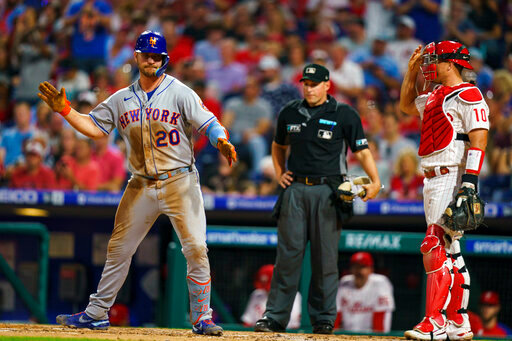 New York Mets' Pete Alonso, left, reacts to his home run as Philadelphia Phillies catcher J.T. Realmuto, right, looks on during the third inning of a baseball game, Friday, Aug. 19, 2022, in Philadelphia. (AP Photo/Chris Szagola)