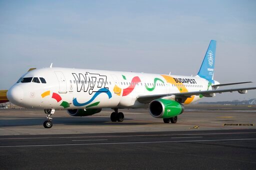 FILE - An aircraft of the low-cost of Wizz Air airlines painted in the colours of the logo of host city candidate Budapest for the 2024 Olympic and Paralympic Games is displayed in Liszt Ferenc International Airport in Budapest, Hungary, Nov. 24, 2016. Hungary's government has ordered an investigation of domestic low-cost carrier Wizz Air over what it calls possible breaches of consumer protection laws, the second such investigation it has launched against an airline since June 2022.  (Szilard Koszticsak/MTI via AP, File )