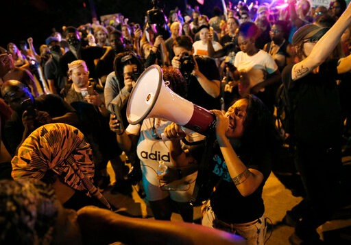 FILE -  LaShell Eikerenkoetter chants, on a megaphone protesting the recent acquittal of a white former police officer, Jason Stockley, in the killing of a black man, Anthony Lamar Smith, on Friday, Sept. 22, 2017 in St. Charles, Mo.  On Aug. 3, Mayor Tishaura Jones signed into law an ordinance establishing a Division of Civilian Oversight. But three police officer associations are suing to stop the measure that they claim hinders due process for officers and conflicts with state law. (David Carson/St. Louis Post-Dispatch via AP)