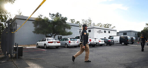 A Pima County constable walks into the crime scene at the Lind Commons Apartments in Tucson, Ariz., on Thursday, Aug. 27, 2022. A local constable  was among four people fatally shot at the apartment complex while serving an eviction notice.  (Kelly Presnell/Arizona Daily Star via AP)