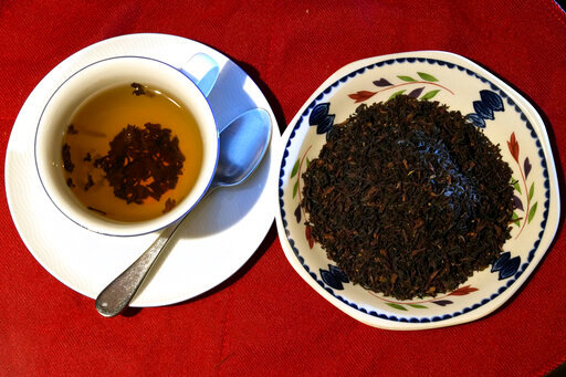 This photo shows a cup of black tea with a spoon and tea leaves pictured in London, Monday, Aug. 29, 2022. According to a large study of British tea drinkers published Monday in Annals of Internal Medicine, scientists found two or more cups daily was tied with a modest benefit: a 9% to 13% lower risk of death from any cause. (AP Photo/Alastair Grant)