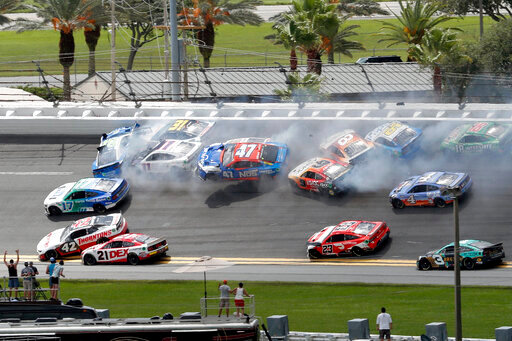 Chris Buescher (17), Daniel Suarez (99), Denny Hamlin (11), Justin Haley (31), Ricky Stenhouse Jr. (47), Aric Almirola (10) and others get involved in a multi-car accident between Turns 1 and 2 during a NASCAR Cup Series auto race at Daytona International Speedway, Sunday, Aug. 28, 2022, in Daytona Beach, Fla. (AP Photo/David Graham)
