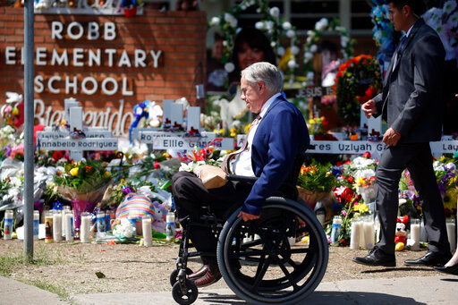 FILE - Texas Gov. Greg Abbott passes in front of a memorial outside Robb Elementary School to honor the victims killed in a school shooting in Uvalde, Texas, May 29, 2022. Abbott on Wednesday, Aug. 31 pushed back on calls by Uvalde families for new gun control measures in Texas, saying that raising the minimum age to purchase weapons like the one used in the Robb Elementary School massacre would be &ldquo;unconstitutional.&quot; (AP Photo/Dario Lopez-Mills, File)