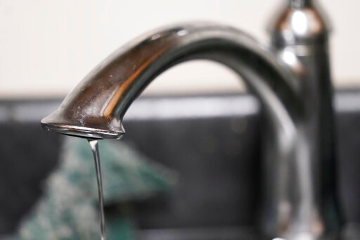 A trickle of water comes out of the faucet of Mary Gaines a resident of the Golden Keys Senior Living apartments in her kitchen in Jackson, Miss., Thursday, Sept. 1, 2022. A recent flood worsened Jackson's longstanding water system problems. (AP Photo/Steve Helber)