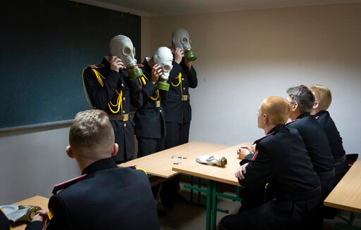Cadets practice with gas masks during a lesson in a bomb shelter on the first day of school at a cadet lyceum in Kyiv, Ukraine, Thursday, Sept. 1, 2022. Fighting raged Friday, Sept. 2, 2022, near Europe's biggest nuclear power plant in a Russian-held area of eastern Ukraine, as experts from the U.N.'s nuclear watchdog agency assessing damage expressed concern over the facility's &ldquo;physical integrity.&rdquo; (AP Photo/Efrem Lukatsky)