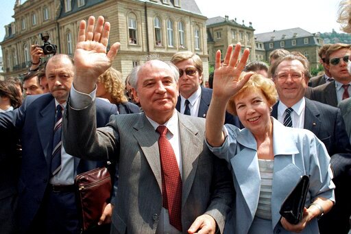 FILE - Soviet President Mikhail S. Gorbachev (l) and his wife Raisa wave to well wishers when strolling through market place in downtown Stuttgart, Wednesday, June 14, 1989. In background is the New Castle where Gorbachev had talks with representatives of West German state Baden-Wurttemberg. When Mikhail Gorbachev is buried Saturday at Moscow's Novodevichy Cemetery, he will once again be next to his wife, Raisa, with whom he shared the world stage in a visibly close and loving marriage that was unprecedented for a Soviet leader. Gorbachev's very public devotion to his family broke the stuffy mold of previous Soviet leaders, just as his openness to political reform did. (AP Photo/Arne Dedert, File)