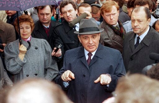 FILE - Soviet President Mikhail S. Gorbachev, his wife Raisa at his side holding an umbrella speak to the media at an polling station in Moscow on March, 26, 1989. When Gorbachev came to power as Soviet leader in 1985, he was younger and more vibrant than his predecessors. He dramatically broke with the Communist past by moving away from a police state, embracing freedom of the press, ending his country's war in Afghanistan and letting go of Eastern European countries that had been locked in Moscow's grip for decades.. (AP Photo/Boris Yurchenko, File)