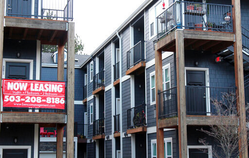 FILE - A 'Now Leasing' sign hangs off an apartment building staircase in southeast Portland, Ore., on Wednesday, Dec. 9, 2021. Rents are starting to come down after spiking to record levels this past summer, but experts are uncertain if the slowdown will continue.  The national median asking rent was up 14% in July 2022 over July the previous year. That's the smallest annual increase since November 2021. Experts say the market could slow further toward the end of the year, but there&rsquo;s still a lot of uncertainty. (AP Photo/Sara Cline, File)
