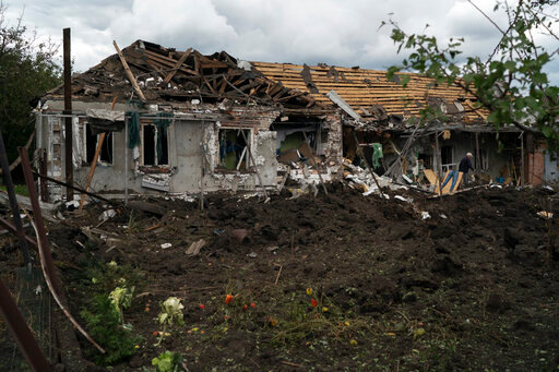 A man walks over the debris of a house that was heavily damaged after a Russian attack in Sloviansk, Ukraine, Tuesday, Sept. 6, 2022. (AP Photo/Leo Correa)