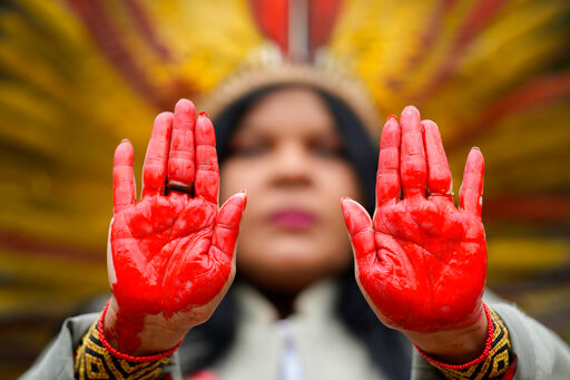 Indigenous leader Sonia Guajajara from the Guajajara ethnic group shows her hands painted in red symbolizing bloodshed, during a protest against violence, illegal logging, mining and ranching, and to demand government protection for their reserves, one day before the celebration of &quot;Amazon Day,&quot; in Sao Paulo, Brazil, Sunday, Sept. 4, 2022. (AP Photo/Andre Penner)