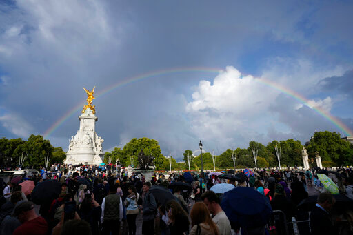 People gather outside Buckingham Palace in London as a double rainbow appears in the sky, Thursday, Sept. 8, 2022. Buckingham Palace says Queen Elizabeth II has been placed under medical supervision because doctors are &quot;concerned for Her Majesty's health.&quot; Members of the royal family traveled to Scotland to be with the 96-year-old monarch. (AP Photo/Frank Augstein)