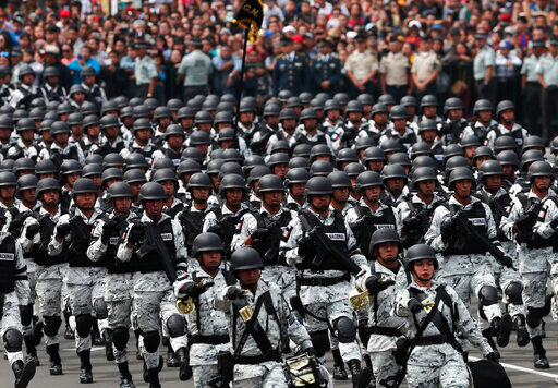FILE - Members of Mexico's National Guard march in the Independence Day military parade, in the capital's main plaza, the Zocalo, in Mexico City, Sept. 16, 2019. Mexico&rsquo;s President Andres Manuel Lopez Obrador has begun exploring plans to side-step congress to hand formal control of the National Guard to the army. That has raised concerns, because Lopez Obrador won approval for creating the force in 2019 by pledging in the constitution that it would be under nominal civilian control and that the army would be off the streets by 2024. (AP Photo/Marco Ugarte, File)