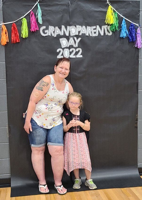Cadence Sickels, right, poses with her grandmother Tena Schlee against a specially decorated wall for Grandparents Day.