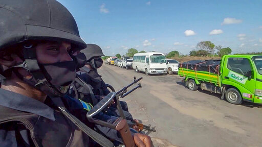 In this image made from video, Rwandan police patrol a road in Palma, Cabo Delgado province, Mozambique, Sunday Aug. 15, 2021. A new offensive by Mozambique's Islamic extremist rebels in Cabo Delgado has increased the number of displaced by 80,000 and undermines the government's claims of containing the insurgency. (AP Photo/Marc Hoogsteyns)