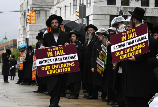 Members of the ultra-Orthodox and Hasidic Jewish communities hold a protest before a Board of Regents meeting to vote on new requirements that private schools teach English, math science and history to high school students on Monday, Sept. 12, 2022, outside the New York State Education Department Building in Albany, N.Y. Leaders of the Hasidic schools say that the new regulations would eliminate their schools where male schools regularly study just the Talmud. Educators say the change will require private schools to provide the basic high school education. (Will Waldron/The Albany Times Union via AP)