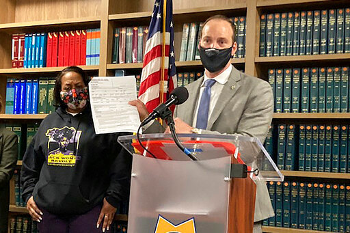 FILE - Former San Francisco District Attorney Chesa Boudin holds a report during a news conference in San Francisco on Feb. 15, 2022. Boudin said the report showed DNA collected by San Francisco police from a woman who was sexually assaulted was used by police detectives to arrest her years later in an unrelated property crime. Attorney Adante Pointer said Monday, Sept. 12, 2022, he has filed a lawsuit against San Francisco on the woman's behalf. (AP Photo/Olga R. Rodriguez, File)