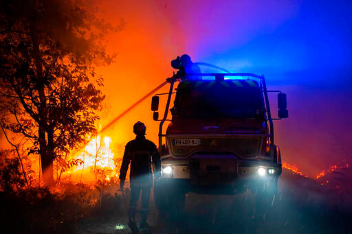 This photo provided by the SDIS33 fire brigade shows firemen trying to pull off a wildfire near the village of Saumos, southwestern France, Monday Sept.12, 2022. New wildfires raging in southwestern France have torn through over 1,000 hectares of land and forced the evacuation of residents amid record temperatures for September. Fires that began to rage Monday caused the evacuation of over 500 in the Gironde region. (SDIS33 via AP)