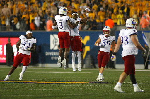 Kansas players celebrate during overtime of an NCAA college football game against West Virginia in Morgantown, W.Va., Saturday, Sept. 10, 2022. (AP Photo/Kathleen Batten)