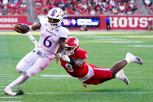 Kansas quarterback Jalon Daniels (6) escapes a tackle by Houston defensive lineman Nelson Ceaser en route to a touchdown during the second half of an NCAA college football game, Saturday, Sept. 17, 2022, in Houston. (AP Photo/Eric Christian Smith)