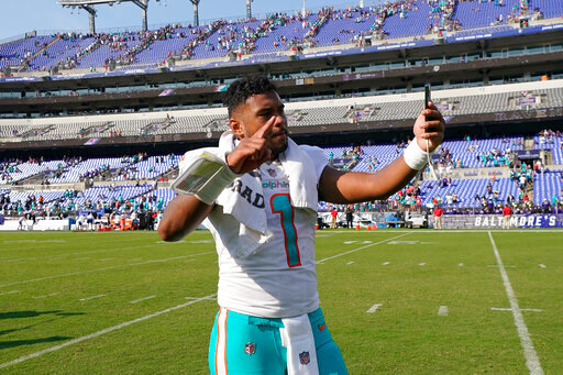 Miami Dolphins quarterback Tua Tagovailoa (1) takes a selfie on the field after defeating the Baltimore Ravens at an NFL football game, Sunday, Sept. 18, 2022, in Baltimore. The Dolphins defeated the Ravens 42-38. (AP Photo/Julio Cortez)