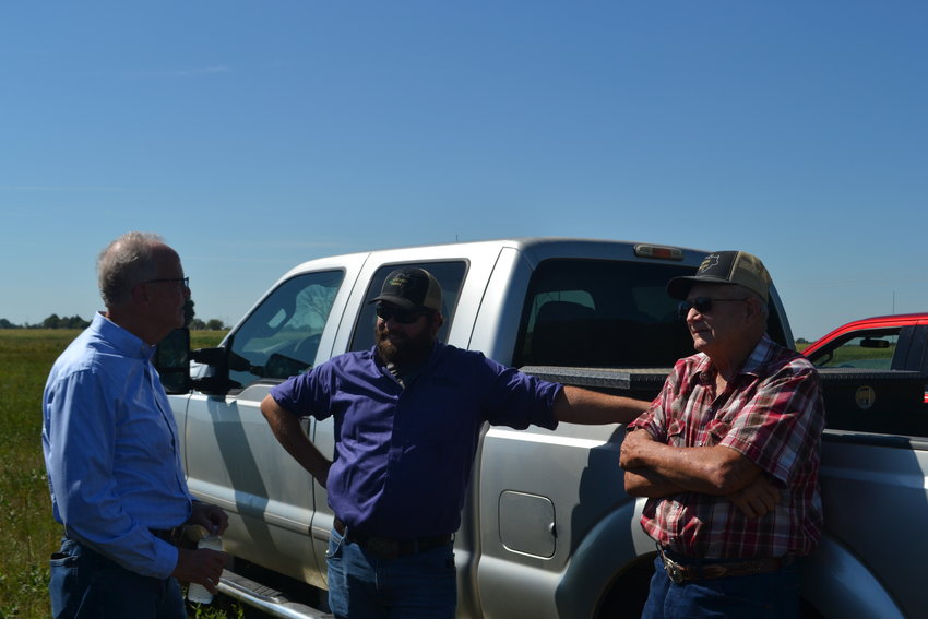 Sen. Jerry Moran talks with Matthew Atkinson and his grandfather, Marion, of Atkinson Farms, LLC, near one of their soybean fields in Scammon. Moran met with the Atkinsons and some other area farmers to get their input as Congress begins building a new farm bill that is due to take effect in October of 2023. &nbsp;