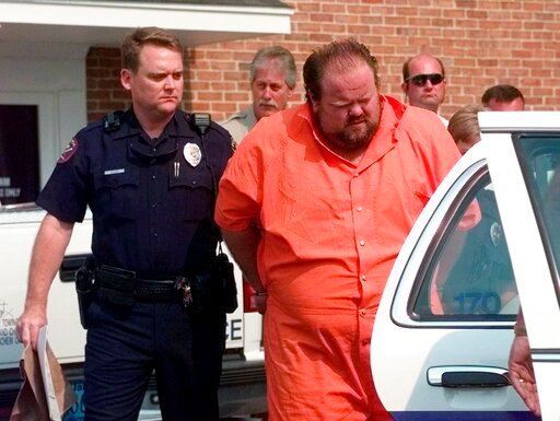 FILE - Officials escort murder suspect Alan Eugene Miller away from the Pelham City Jail in Ala., on Aug. 5, 1999. Miller, scheduled to be put to death by lethal injection on Sept. 22, 2022, for a workplace shooting rampage in 1999 that killed three men, says the state lost the paperwork he turned in selecting an alternate execution method. (AP Photo/Dave Martin, File)