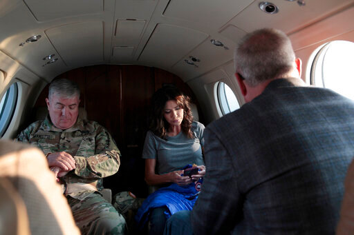 FILE - South Dakota Gov. Kristi Noem, center, checks her phone before taking off, Monday, July 26, 2021 in Pierre, S.D.  Noem is under investigation for using a state-owned airplane to fly to political events and bring family members with her on trips. But the decision on whether to prosecute the Republican governor likely hinges on how a county prosecutor interprets an untested law that was passed by voters in 2006. (AP Photo/Stephen Groves)