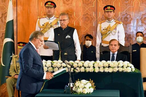In this photo released by Press Information Department, Pakistan's President Arif Alvi, center, administrates oath from newly appointed Finance Minister Ishaq Dar, left, as Prime Minister Shehbaz Sharif, right, watches during a ceremony in Islamabad, Pakistan, Wednesday, Sept. 28, 2022. Pakistan appointed a new finance minister on Monday as the impoverished nation struggles to recover from an economic crisis worsened by deadly floods. (Press Information Department vis AP)