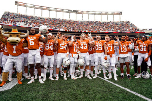 FILE - Texas players sing &quot;The Eyes Of Texas,&quot; after defeating Kansas State 22-17 in an NCAA college football game in Austin, Texas, on Nov. 26, 2021. The new business world of college athletes getting paid for endorsements has created a rapidly expanding pop-up industry: nonprofits formed to set up athletes with deals that pay them to promote charities. Among the first was Horns With Heart, a nonprofit set up to aid offensive linemen at the University of Texas in 2021. A bill filed Wednesday, Sept. 28, 2022, would eliminate the tax deduction for individuals and for specific contributions that are then paid to athletes for name, image and likeness deals. (AP Photo/Chuck Burton, File)