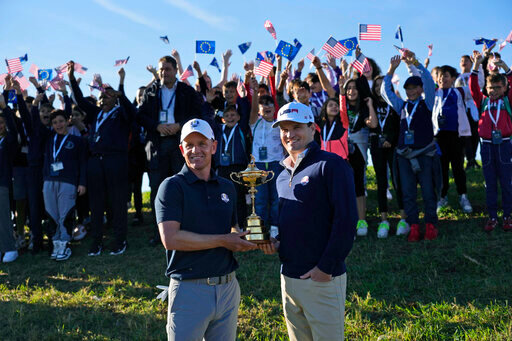 European Captain Luke Donald, left, and United States Captain Zach Johnson pose with the Ryder Cup trophy before an exhibition match on the occasion of The Year to Go event at the Marco Simone course that will host the 2023 Ryder Cup, in Guidonia Montecelio, near Rome, Italy, Monday, Oct. 3, 2022. (AP Photo/Alessandra Tarantino)