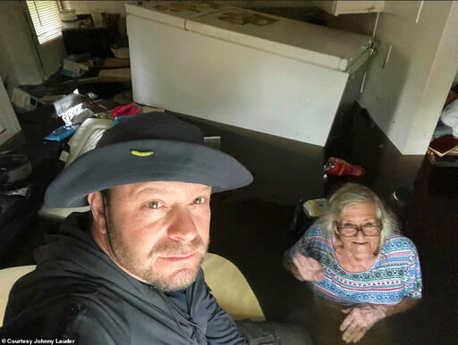 In this photo provided by Johnny Lauder, Lauder takes a selfie with his mother, Karen Lauder, 86, as he came to rescue her after water flooded her home, in Naples, Fla., Wednesday, Sept. 28, 2022, following Hurricane Ian. (Johnny Lauder via AP)