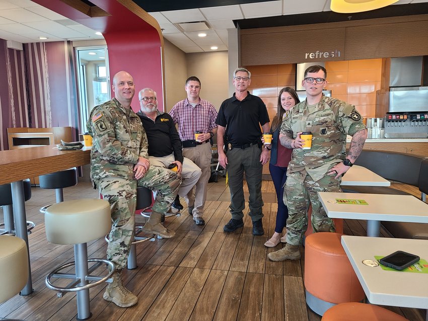 From left, Staff Sergeant Spencer Herness, Detective James Hogue, Major Ben Henderson, Detective John Harrison, Administrative Assistant Jacquelyn Eighmy, and Sergeant Michael Bean gather at McDonald&rsquo;s on North Broadway on Wednesday morning for the Pittsburg Police Department&rsquo;s Faith and Blue Coffee with a Cop event.
