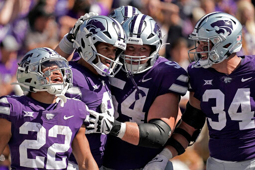 Kansas State quarterback Adrian Martinez, second from left, celebrates with teammates after scoring a touchdown during the second half of an NCAA college football game against Texas Tech Saturday, Oct. 1, 2022, in Manhattan, Kan. Kansas State won 37-28. (AP Photo/Charlie Riedel)