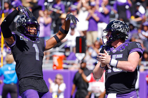 TCU quarterback Max Duggan (15) and teammate Quentin Johnston (1) celebrate Duggan's touchdown against Oklahoma during the second half of an NCAA college football game Saturday, Oct. 1, 2022, in Fort Worth, Texas. TCU won 55-24. (AP Photo/Ron Jenkins)