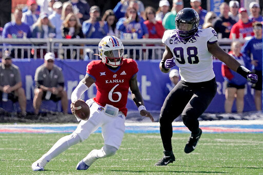 Kansas quarterback Jalon Daniels (6) is chased by TCU defensive lineman Dylan Horton (98) during the first half of an NCAA college football game Saturday, Oct. 8, 2022, in Lawrence, Kan. (AP Photo/Charlie Riedel)